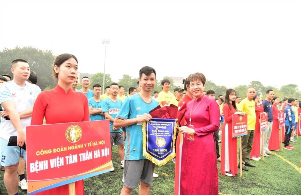 Tổng Biên tập báo Lao động Thủ đô Lê Thị Bích Ngọc tặng Cờ lưu niệm cho các cầu thủ công nhân. Ảnh: Hà Anh