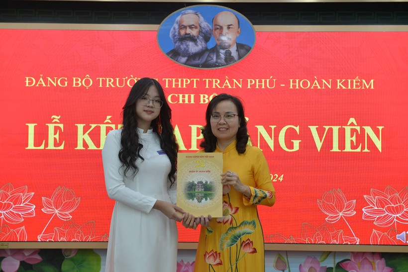 Bí thư Đảng ủy, Hiệu trưởng trường THPT Trần Phú Trần Thị Hải Yến trao quyết định kết nạp cho đảng viên mới Trần Linh Đan.