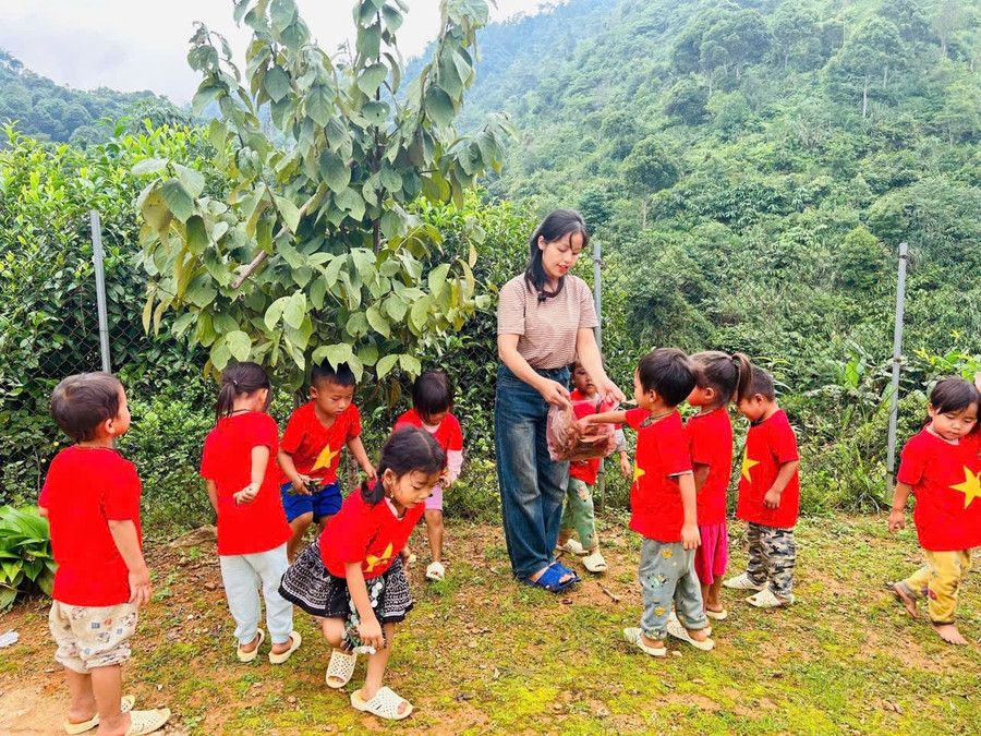 Cô Sộng Me Chung bên những em học sinh Làng Mảnh. Ảnh: Đức Hạnh