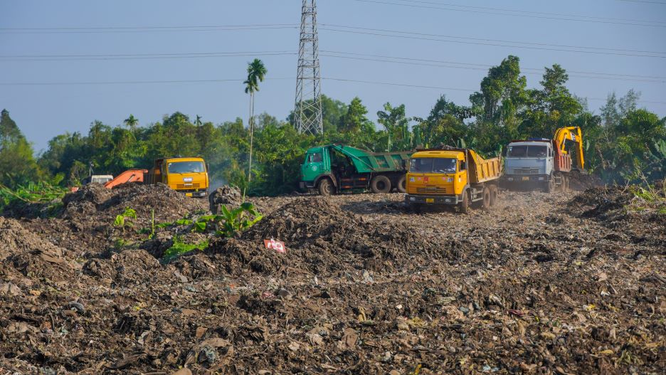 Thiết bị máy móc cùng nhân công tất bật di dời bãi rác. Ảnh: Tạ Quang
