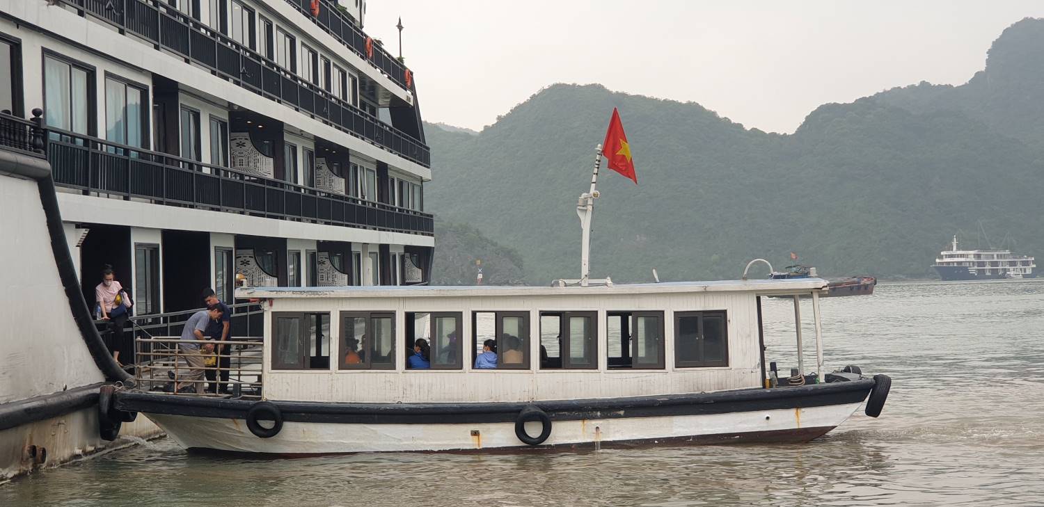 Một tàu nhỏ đón khách từ Cảng Tuần Châu, vịnh Hạ Long và đưa ra tàu nghỉ đêm đang đợi trên vịnh Lan Hạ. Ảnh: Nguyễn Hùng