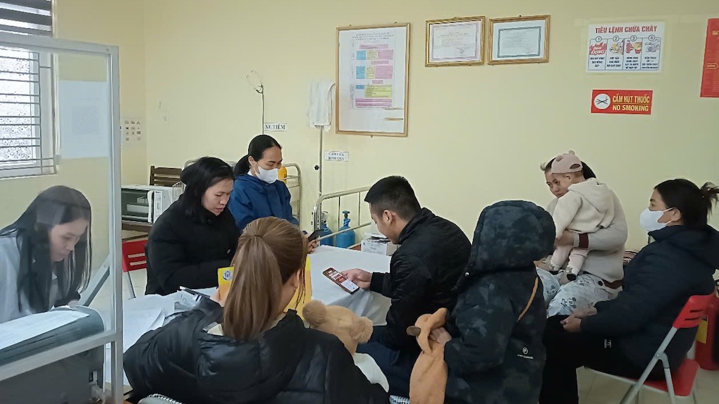 Đoàn viên thanh niên huyện Nam Sách hướng dẫn người dân sử dụng ứng dụng sổ sức khỏe điện tử. Ảnh: Cổng TTĐT tỉnh Hải Dương