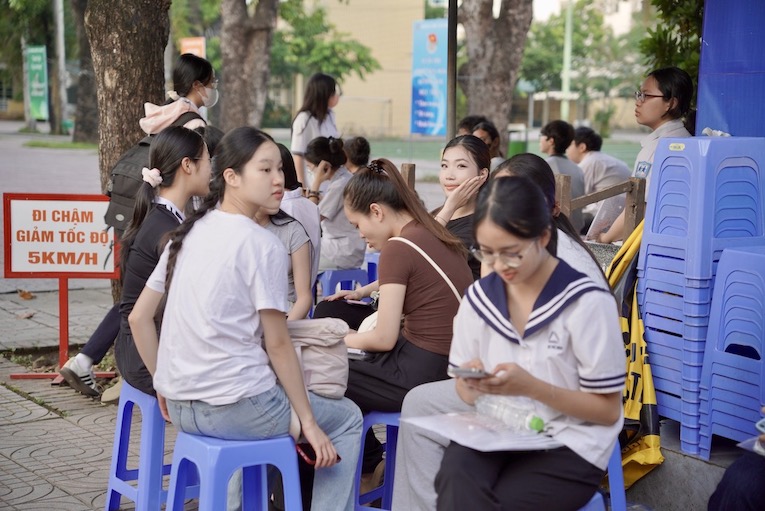 Thí sinh dự thi tại điểm thi Trường THPT Yên Hoà đến sớm, tranh thủ gửi đồ, ôn lại bài trước khi vào phòng thi. Ảnh: Thiều Trang