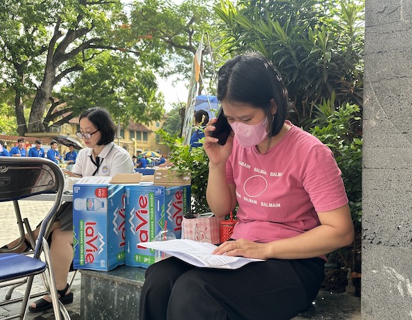 Cô giáo Lê Thị Thanh Tuyến - Trung tâm Giáo dục nghề nghiệp, Giáo dục Thường xuyên Tây Hồ - đang gọi điện cho người nhà các thí sinh chưa có mặt tại điểm thi. Ảnh: Anh Đức