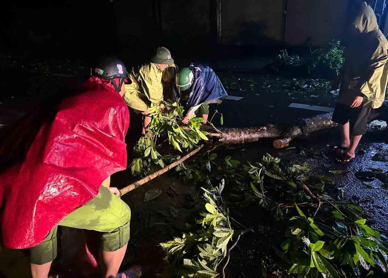 Lực lượng Công an nhiều địa phương ở Hà Tĩnh trắng đêm cắt dọn cây cối đổ do bão để thông đường. Ảnh: Công an Hà Tĩnh.