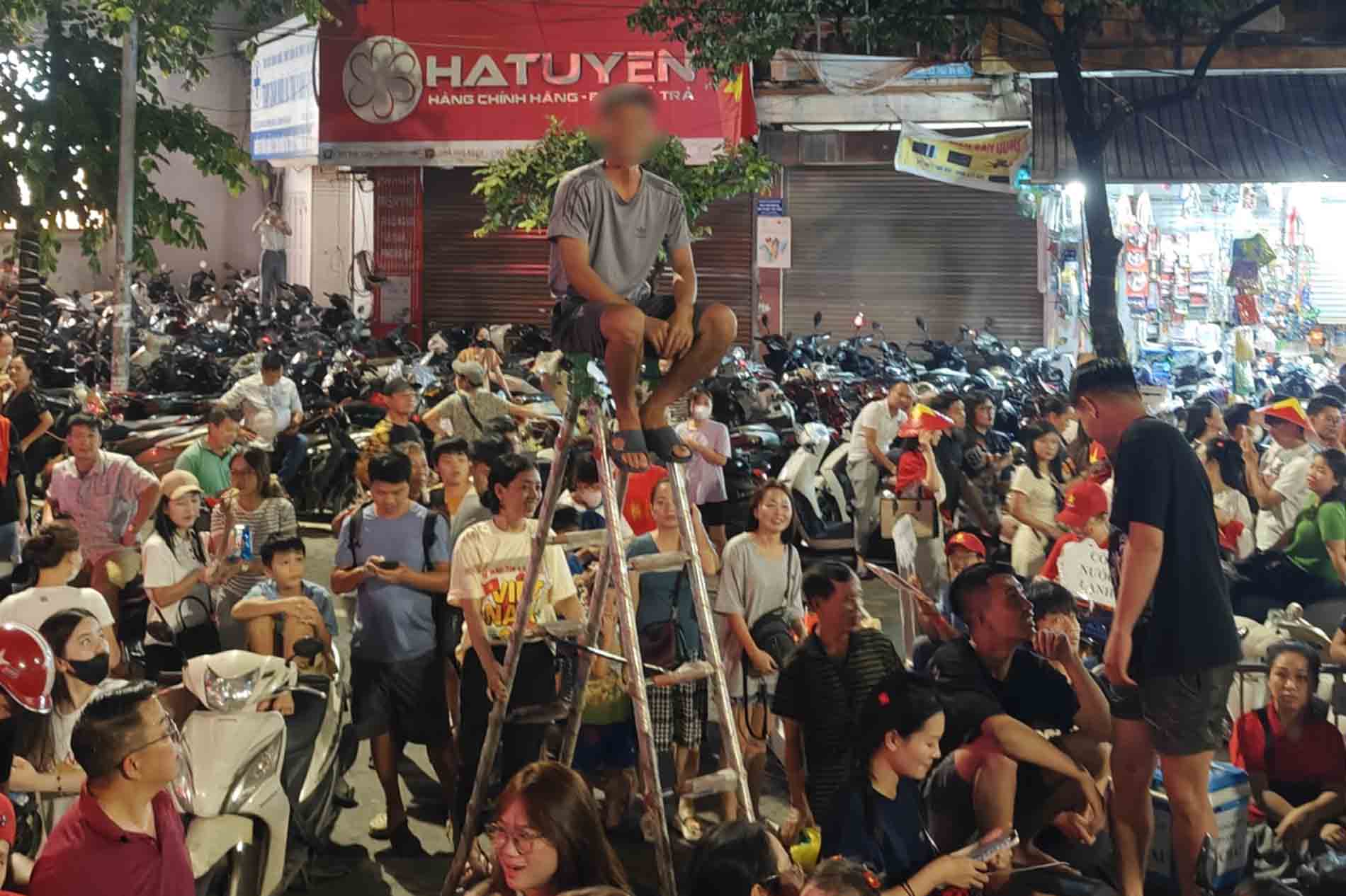 Một người dân thuê thang để xem sơ duyệt diễu binh, diễu hành ngày 27.8. Ảnh: Anh Tú
