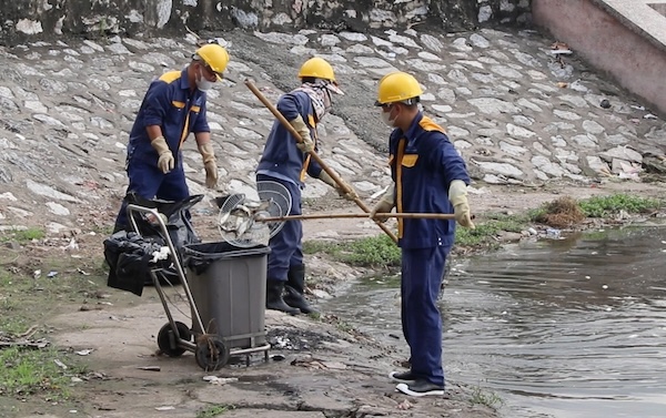 Công nhân môi trường hằng ngày phải trực, trục vớt xác cá chết tại hồ Đầm Hồng. Ảnh: Nguyễn Linh