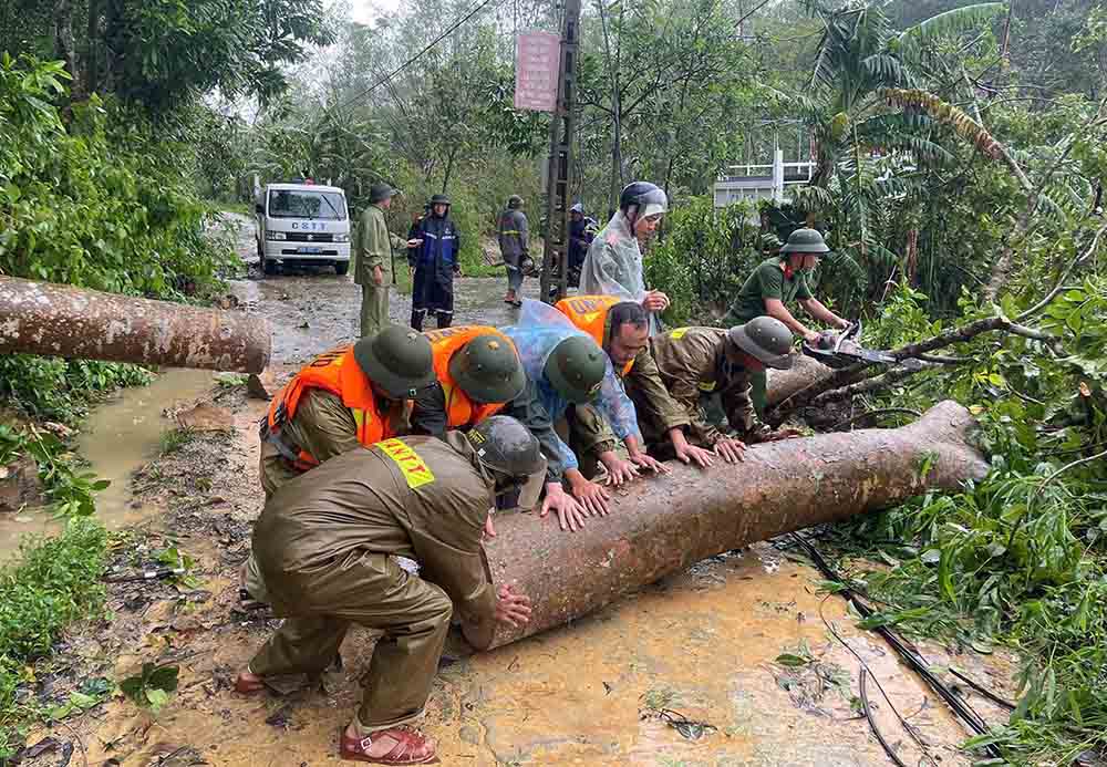 Công an cắt dọn cây đổ chắn ngang đường. Ảnh: Công an Hà Tĩnh.