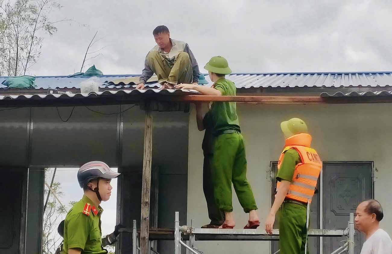 Công an xã Kỳ Hoa lợp lại nhà bị tốc mái cho gia đình bà Đào Thị Nước - là vợ Liệt sĩ. Ảnh: Công an Hà Tĩnh.