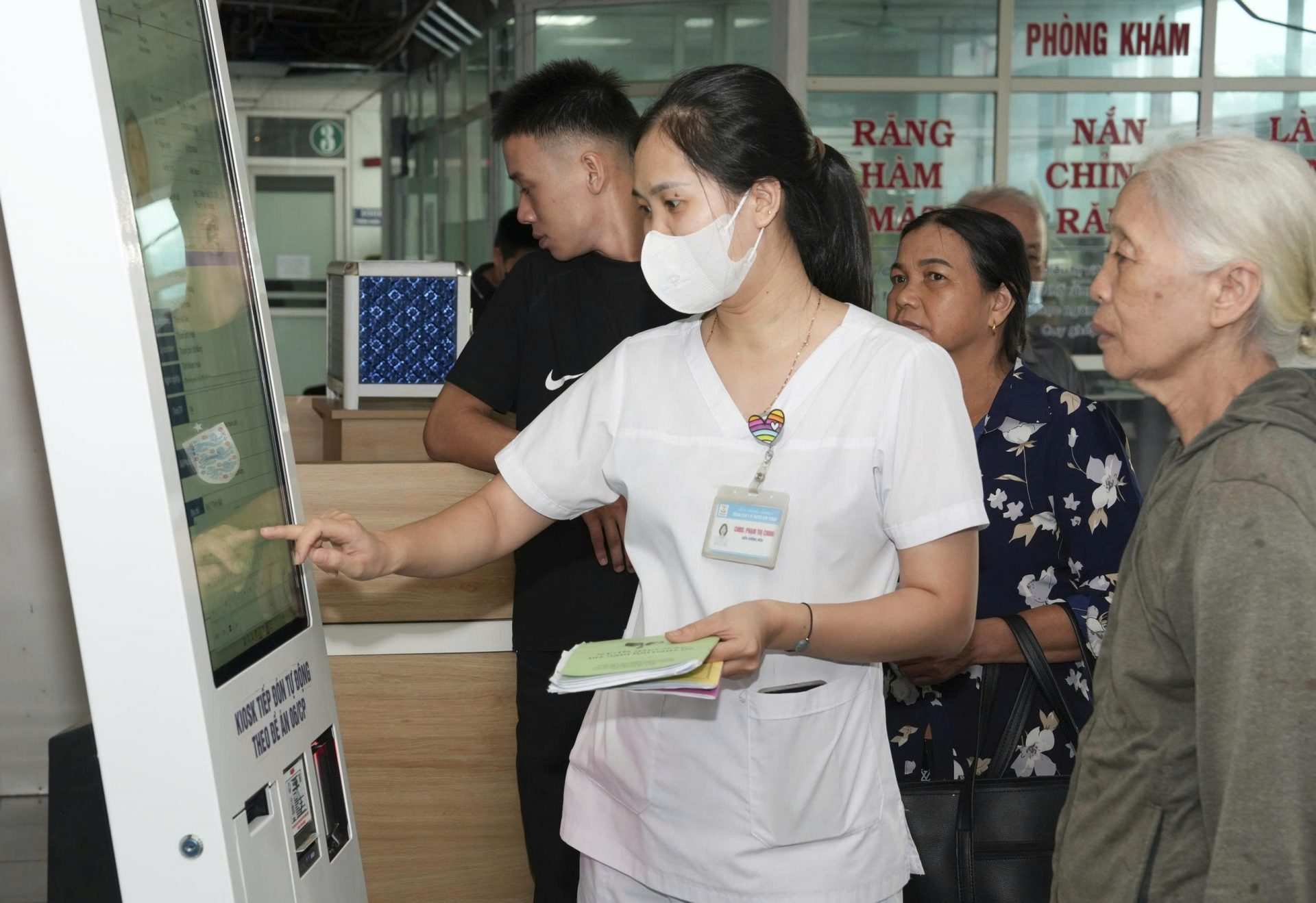 Cán bộ Trung tâm Y tế Kim Thành hướng dẫn người cao tuổi khi đi đăng ký khám, chữa bệnh. Ảnh: CDC Hải Phòng