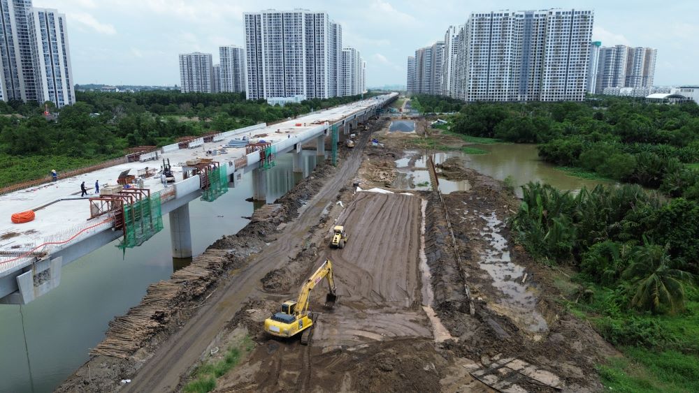 Máy cẩu, xe lu, thiết bị thi công phủ kín dọc tuyến cầu cạn, tạo nên nhịp độ khẩn trương của đại công trường khu Đông.
