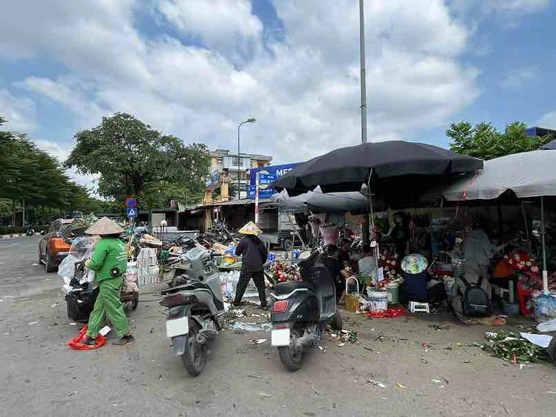 Nhân viên môi trường cùng chủ các gian hàng hoa quét dọn để chuẩn bị thu gom sau ngày buôn bán. Ảnh: Thúy Hiền