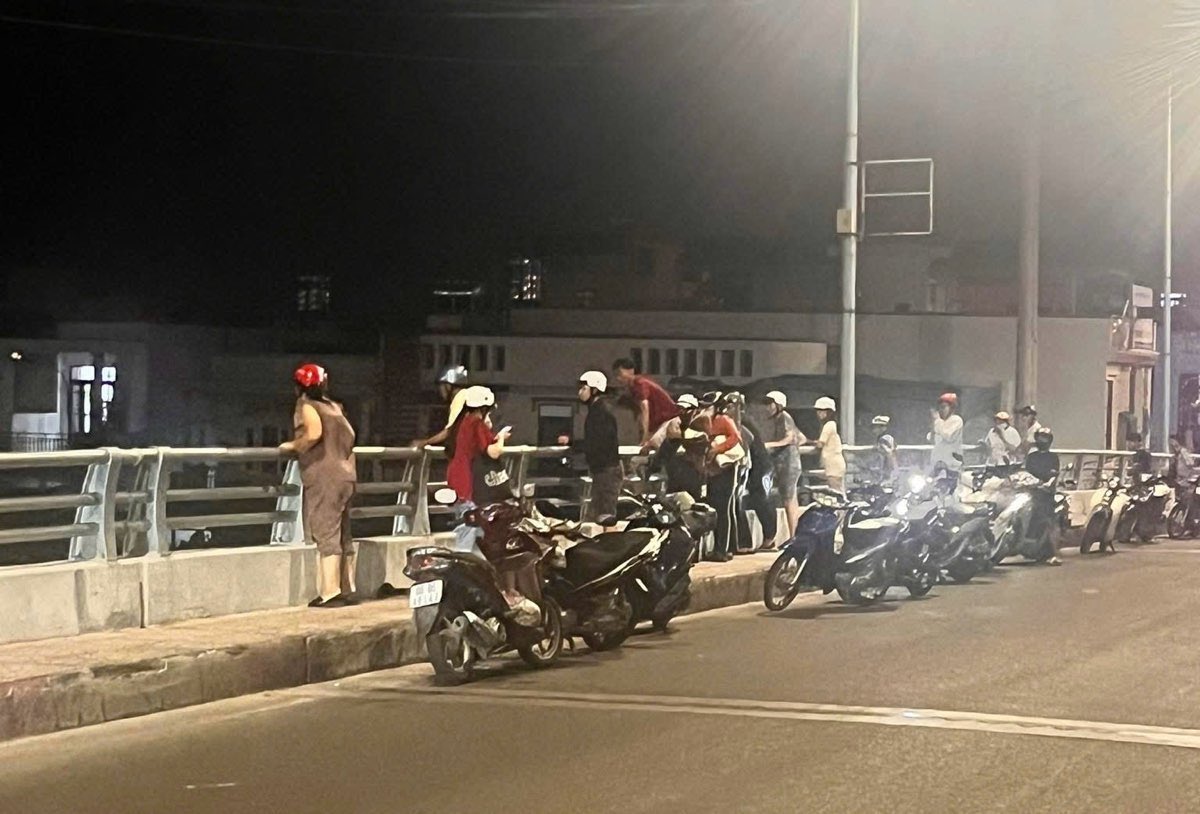 Nhiều người đứng trên cầu Tân Lý xem cứu người. Ảnh: Duy Tuấn