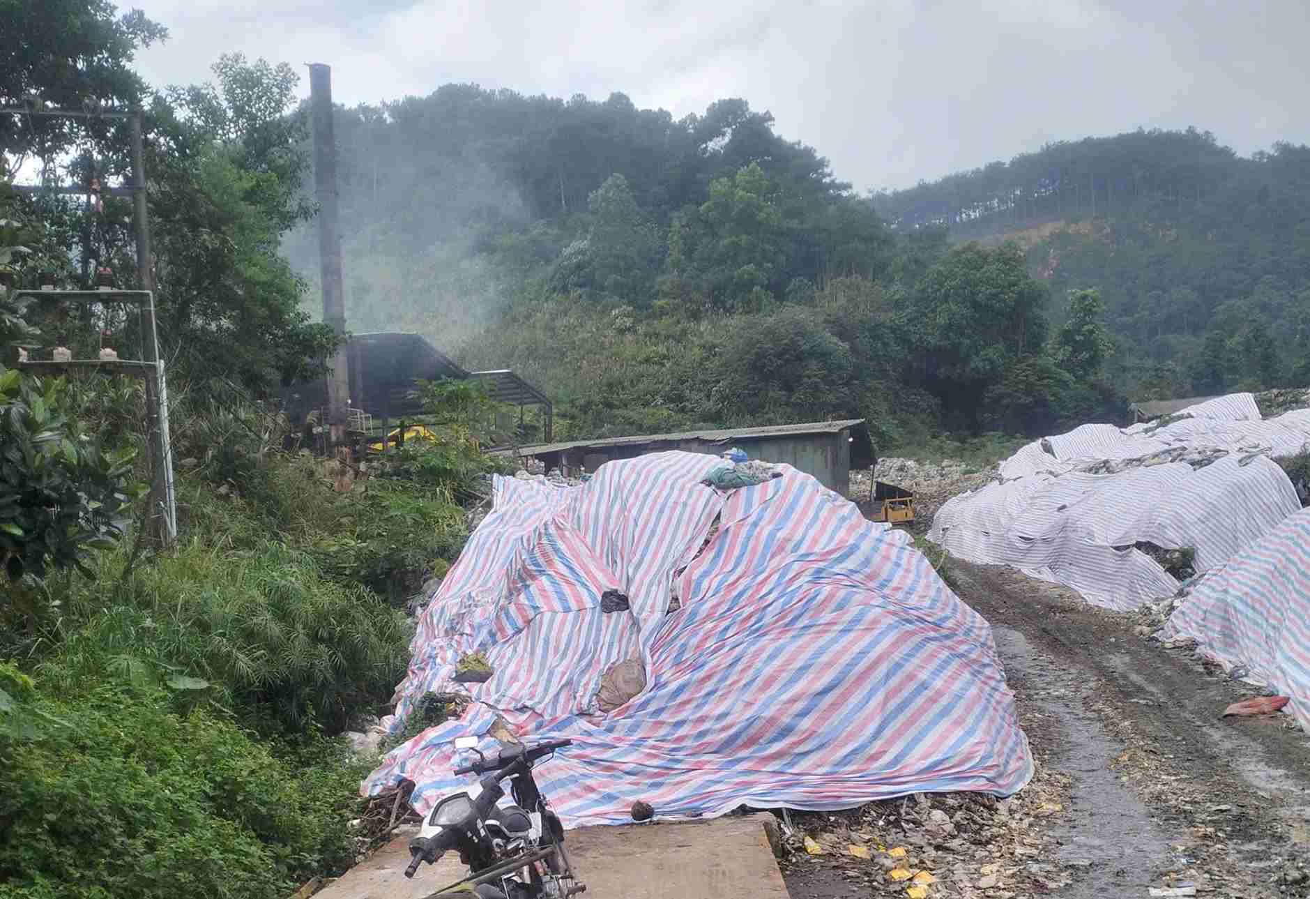 Lượng rác ứ đọng dọc theo đường nội bộ của Nhà máy được phủ bạt hạn chế ô nhiễm môi trường. Ảnh: Phúc Khánh