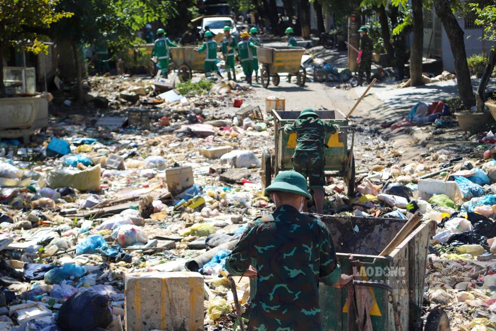 Tay xẻng, tay cào, từng người miệt mài xúc từng đống bùn, từng bao rác để trả lại vẻ sạch sẽ cho phố phường.