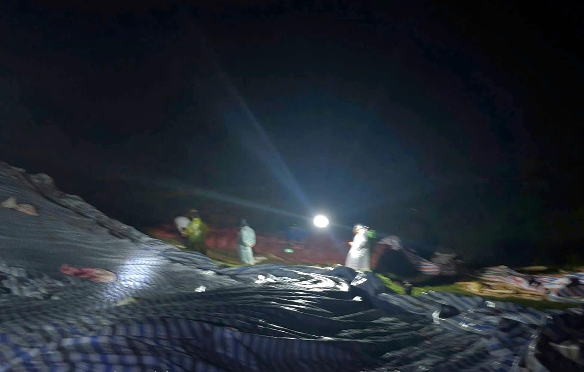 Các lực lượng xuyên đêm nỗ lực gia cố thân đập Cay An. Ảnh: Hải Đường