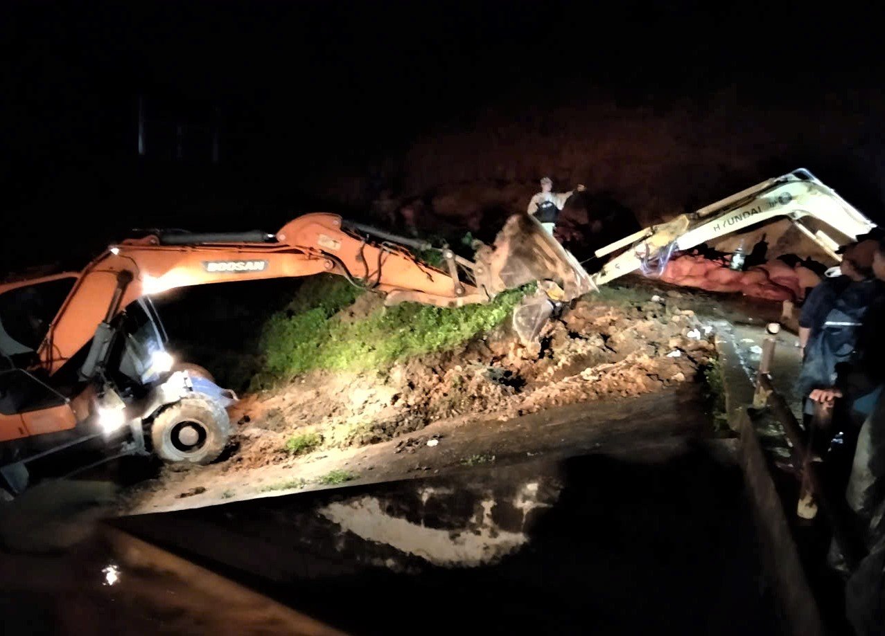 Máy múc được huy động để gia cố đập thủy lợi Cay An. Ảnh: Hải Đường