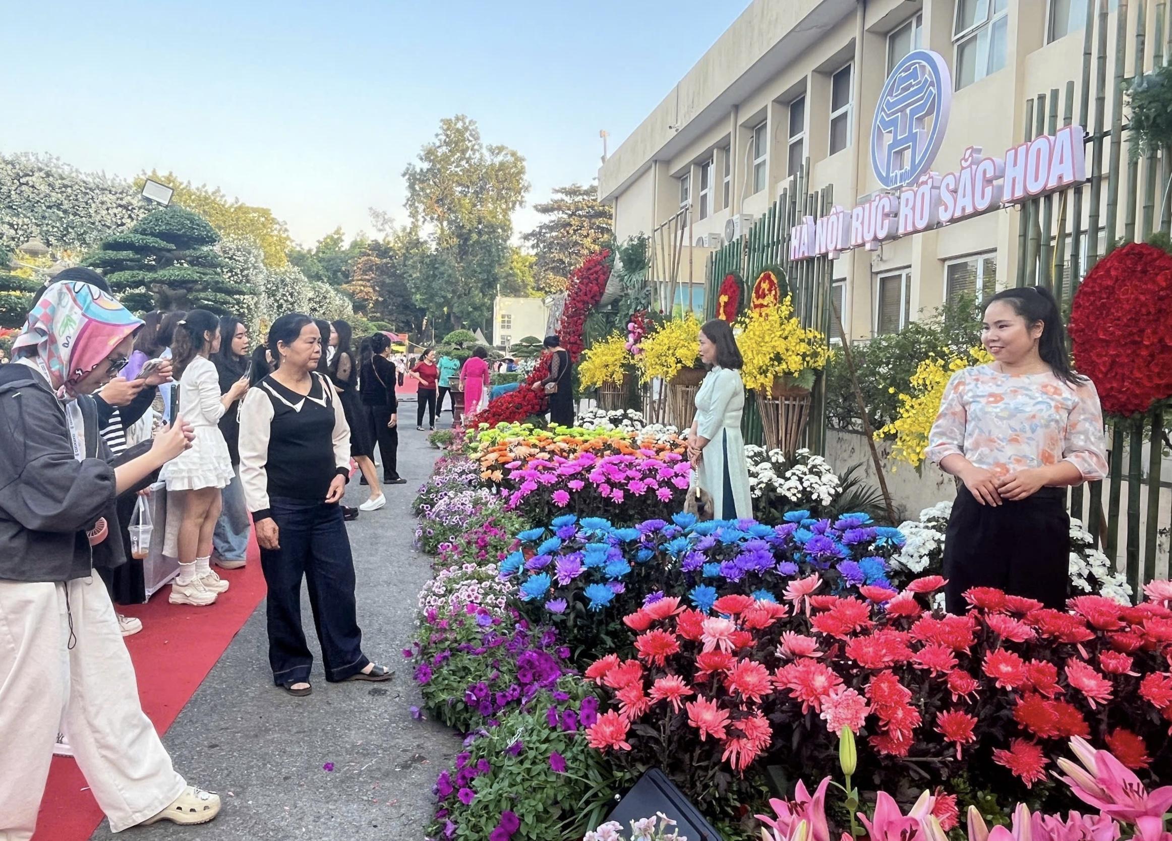 Du khách hào hứng chụp ảnh tại không gian hoa rực rỡ ở Festival Bảo tồn và Phát triển làng nghề 2025. Ảnh: Lê Tuyến