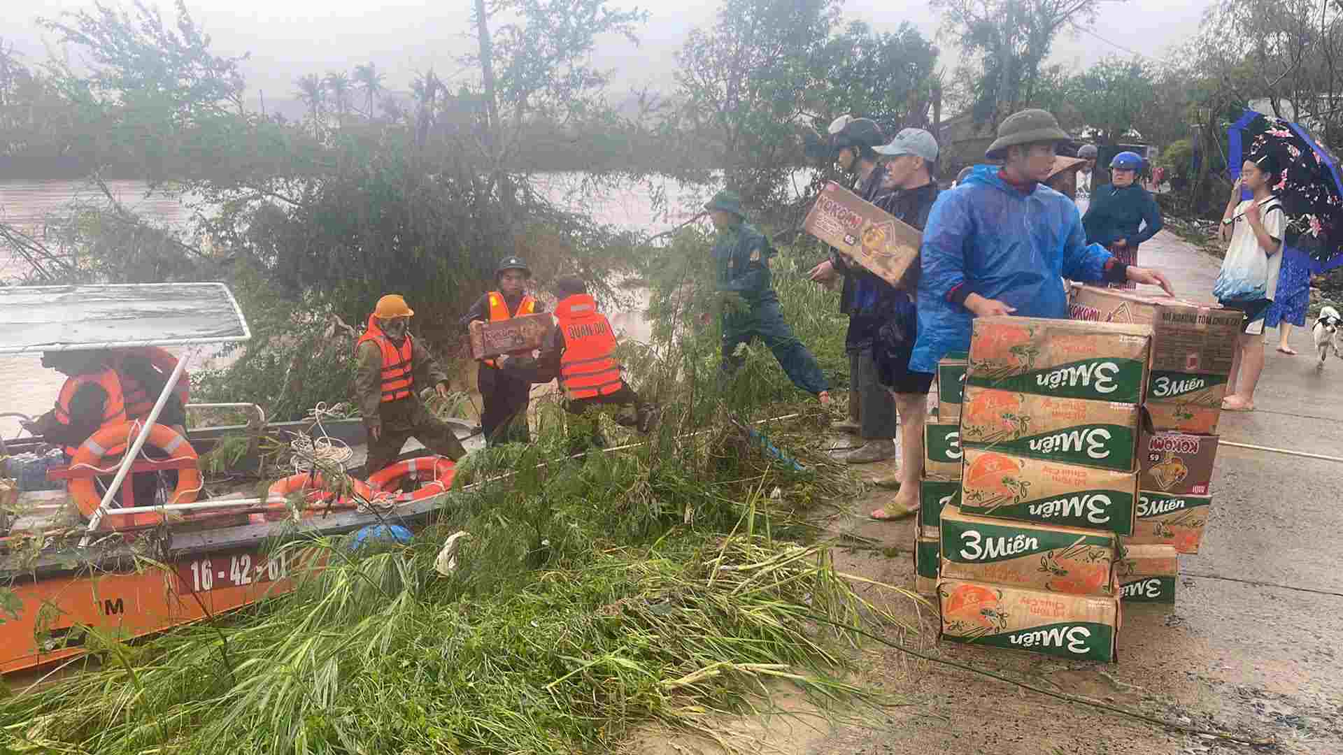 Bên cạnh việc ứng cứu người, quân đội đồng thời triển khai cứu trợ dân vùng lũ. Ảnh: Phạm Quang