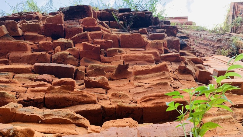 Mảng tường gạch lởm chởm, xuống cấp ở cửa giả di tích tháp Chăm Khương Mỹ, nhưng không thuộc hạng mục đầu tư trùng tu trong gói thầu 12,6 tỉ. Ảnh: Nhóm PV