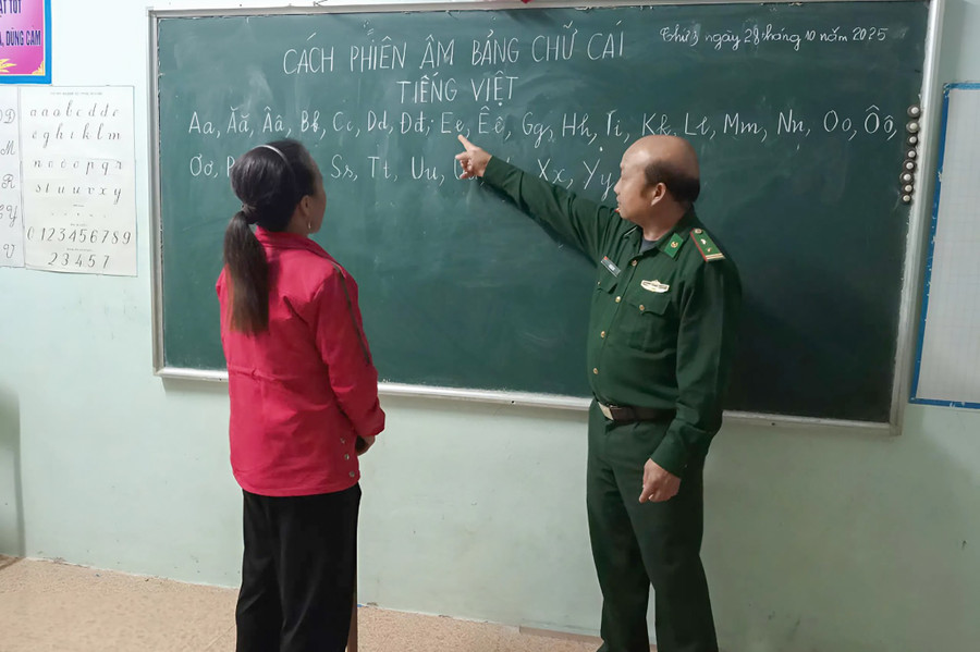 Trung tá Cự Bá Pó hướng dẫn học viên đọc chữ. xoa-mu-chu-pieng-vai-2.jpg