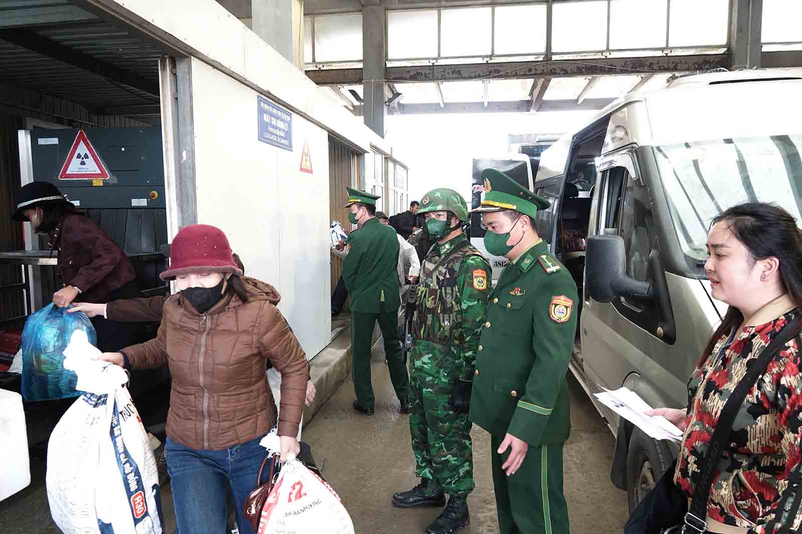 Người dân nhận hành lý sau khi đã qua băng tải soi bằng máy nhằm phát hiện hàng cấm. Ảnh: Trần Tuấn.