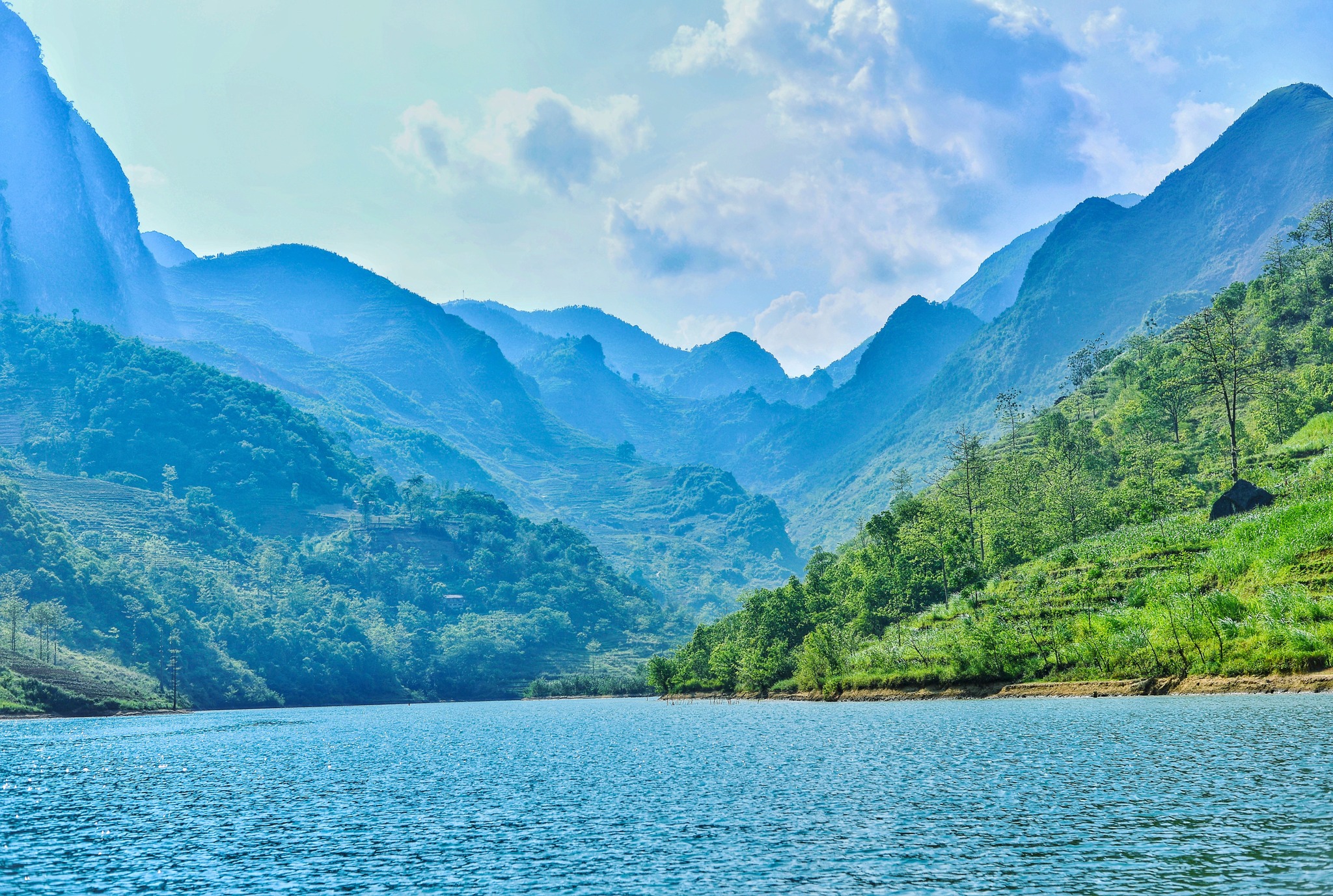 Sông Nho Quế (Tuyên Quang) không chỉ nổi tiếng với màu nước xanh ngọc bích mà còn bởi sự tương phản ngoạn mục với khung cảnh xung quanh. Nơi đây là minh chứng sống động cho sức mạnh kiến tạo của thiên nhiên, khi một dòng nước hiền hòa lại len lỏi qua chân những vách đá tai mèo hiểm trở của hẻm vực Tu Sản sâu nghìn mét.