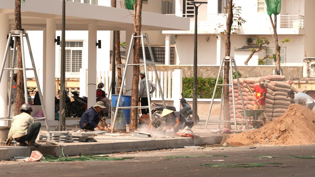 Công nhân đang lắp những viên gạch cuối cùng hoàn thiện phần mở rộng quảng trường Tam Thắng. Ảnh: Thành An