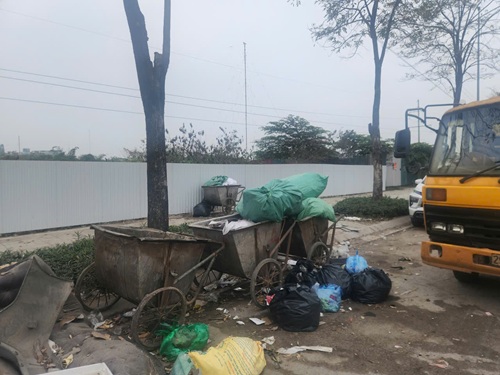 Rác thải vây quanh điểm tập kết rác tại phố Phạm Tu. Ảnh: Đặng Tiến