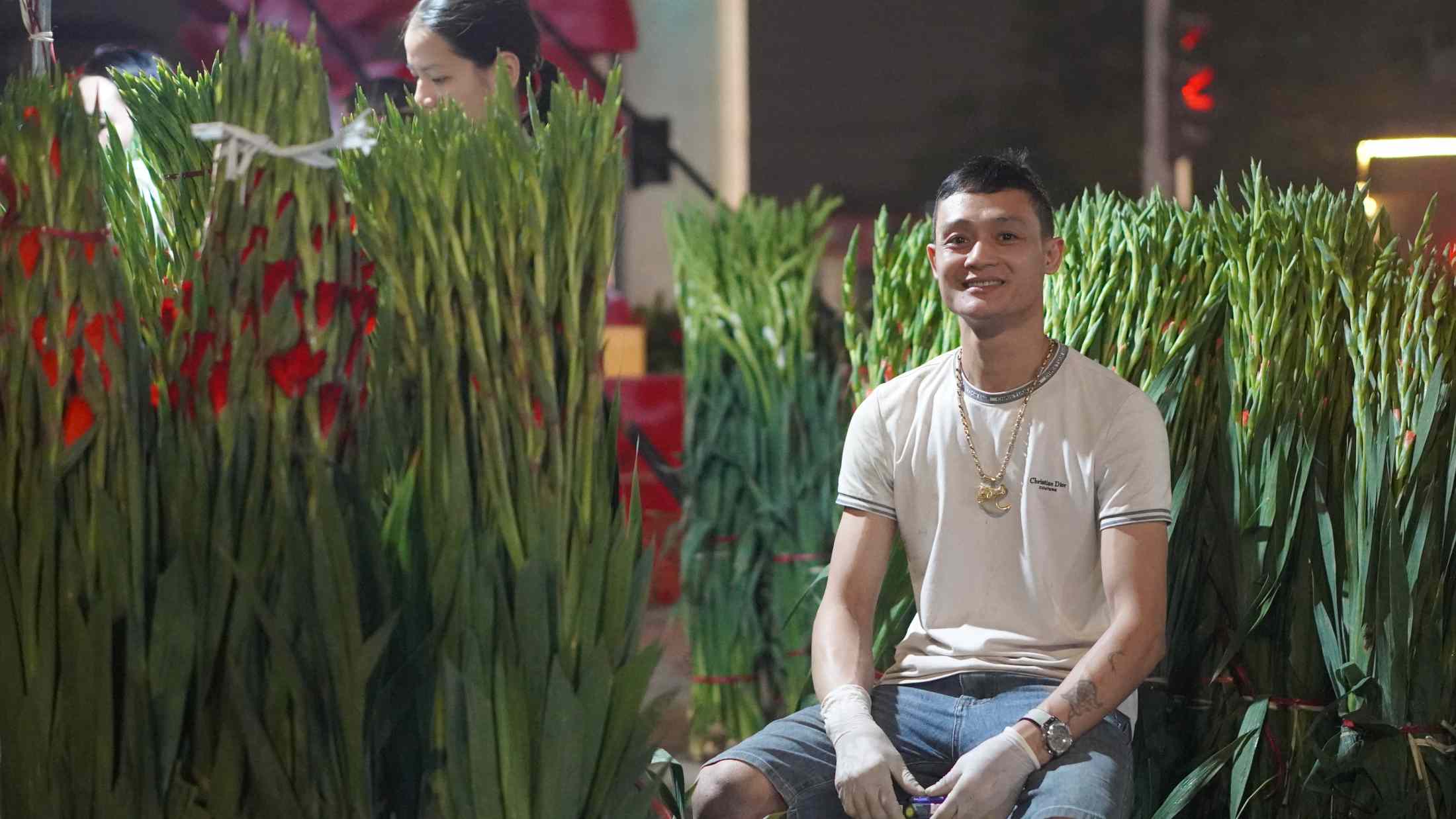 Nụ cười của anh Toàn khi những bó hoa được bán khá chạy trong đêm Rằm. Ảnh: Minh Vũ