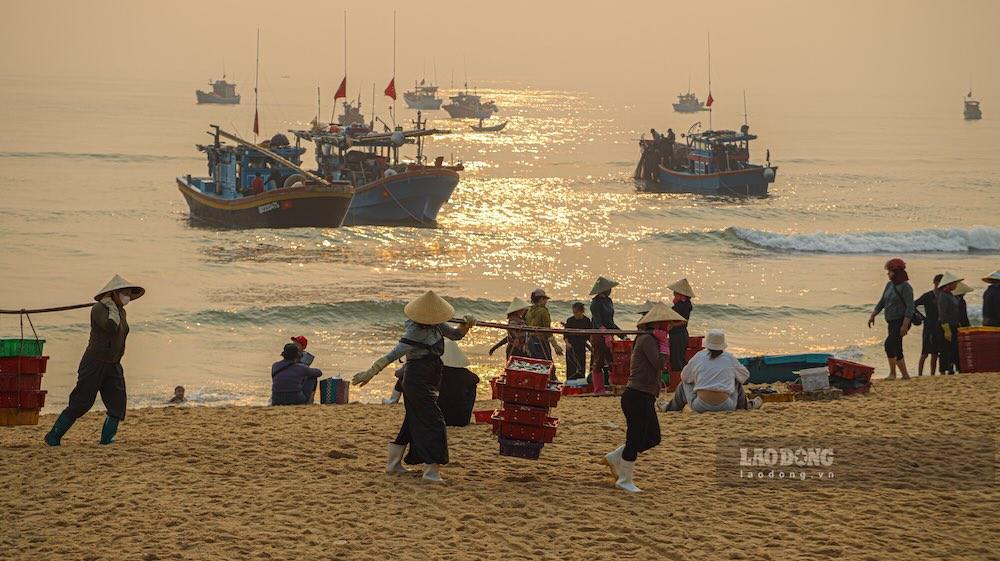 Những người phụ nữ sẽ gánh toàn bộ cá nục đánh bắt được lên chợ tạm trên bờ cho thương lái. Ảnh: Nguyễn Luân