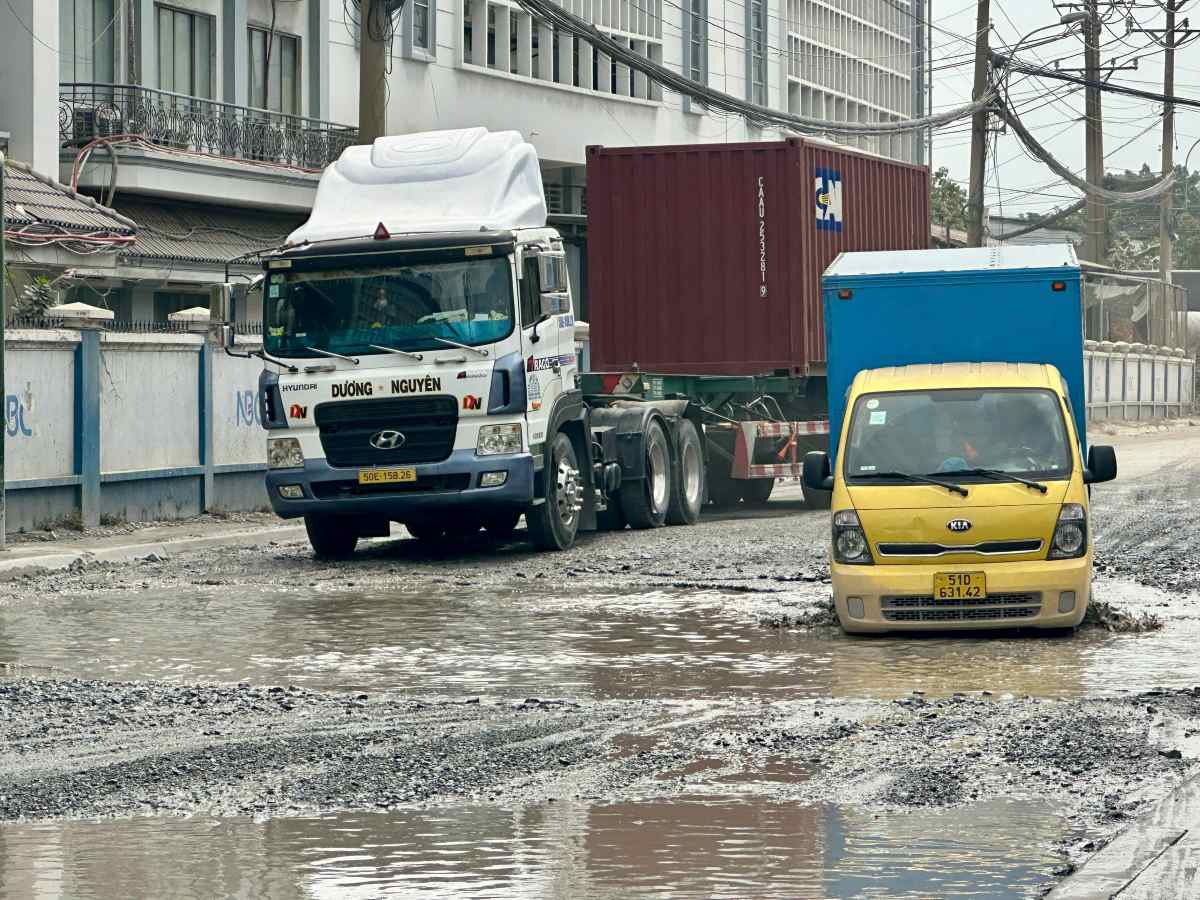 Nước ngập bánh xe tải khi đi qua hố. Ảnh: Minh Tâm