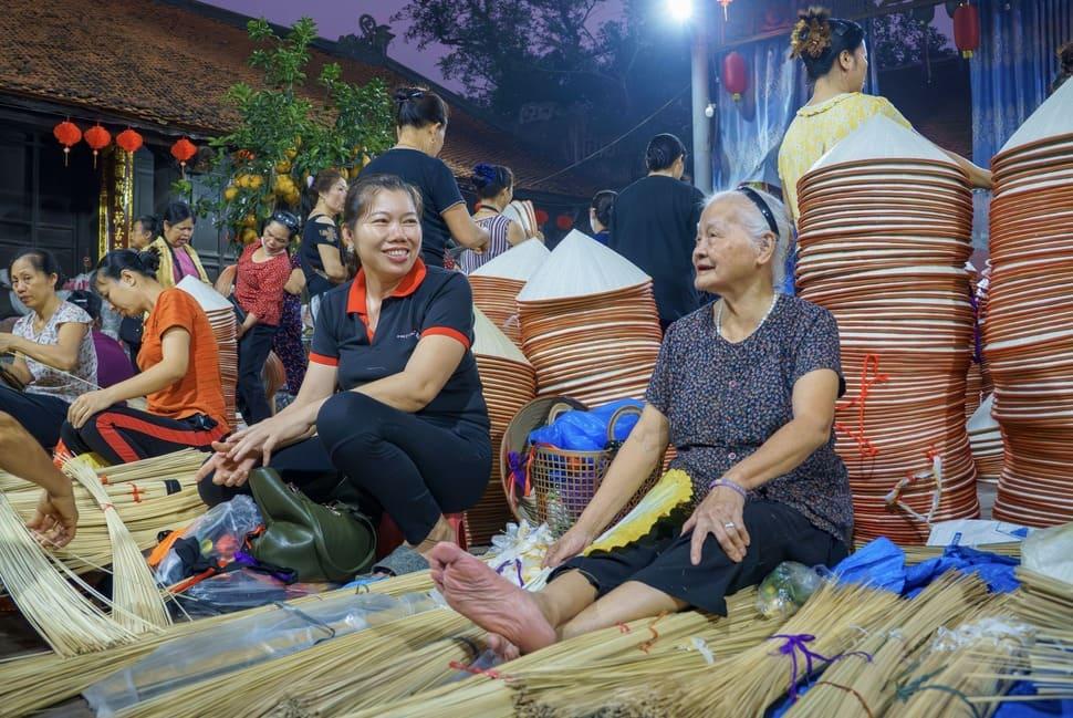 Chợ nón làng Chuông không chỉ là nơi mua bán mà còn là không gian gặp gỡ nơi người dân vừa tư vấn vừa bán sản phẩm, vừa chia sẻ những câu chuyện đời thường. Ảnh: Nguyễn Thuý