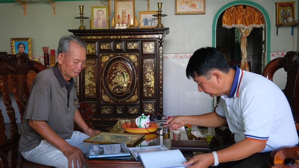 Nhà báo thương binh Hoàng Dũng bên những tác phẩm tác nghiệp trong kháng chiến chống Mỹ để chia sẻ với phóng viên báo Lao Động. Ảnh: Phong Linh.