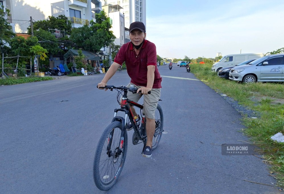 Ông Trần Văn Sơn đạp xe trên tuyến đường ven kênh. Ảnh: Minh Quân
