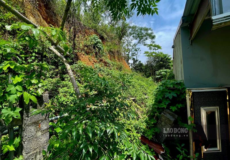 Khu vực sạt lở phía sau ngôi nhà anh Tuấn, đất đá tràn xuống tường nhà. Ảnh: Minh Hoàng