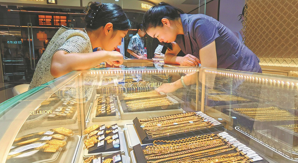 Người tiêu dùng xem trang sức vàng tại một cửa hàng ở Từ Châu, tỉnh Giang Tô, Trung Quốc. Ảnh: China Daily. 68b8f290a3108622d640f90c.jpg